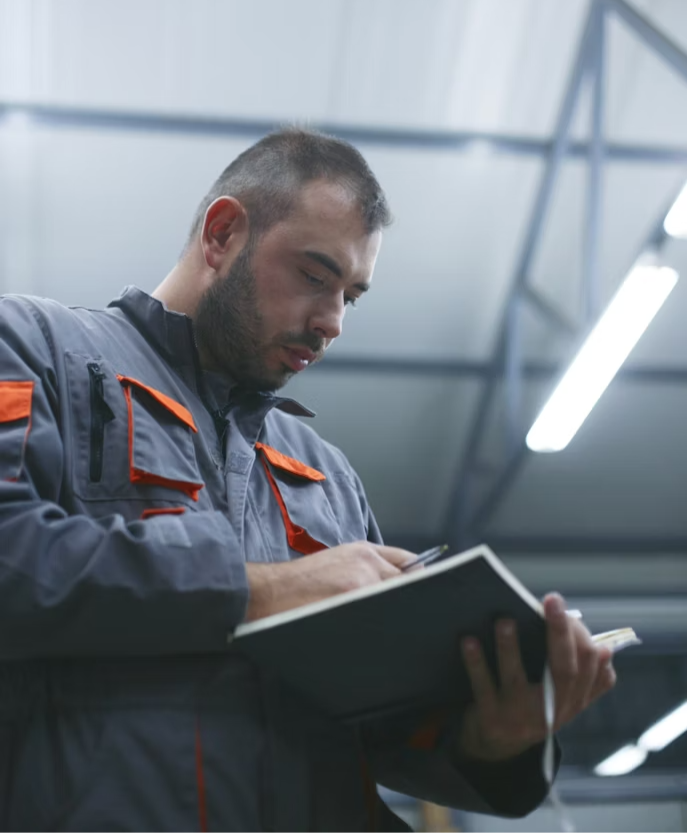 A worker reviewing notes on a job site